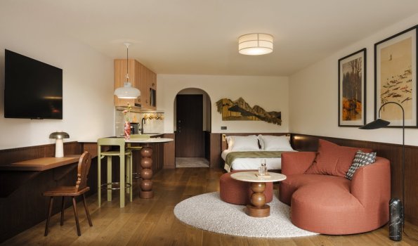 Moderne Wohnung mit Kochnische und Sitzbereich In dieser Wohnung sieht man einen Schlafbereich, eine Kochnische und einen Sitzbereich. Das Licht ist warm und freundlich.