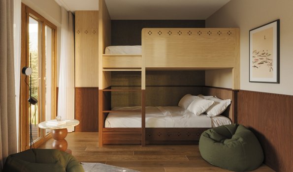 Ein Zimmer mit einem Hochbett und einem Sofa Das Zimmer zeigt ein Hochbett und ein Wohnzimmer mit einem Sofa. Es gibt Fenster, die Tageslicht einlassen.