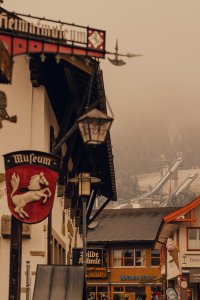 In Garmisch-Partenkirchen sind alte Gebäude und Geschäfte zu sehen. Die Wolken hängen tief über den Bergen.