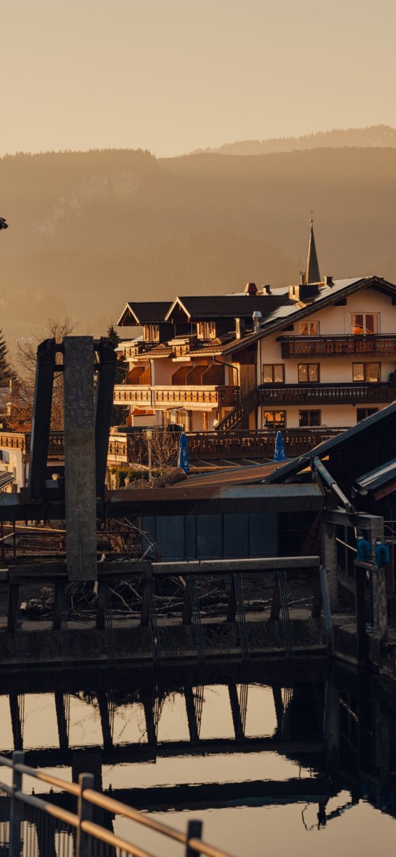 Die Sonne geht unter und beleuchtet die Gebäude in der Stadt. Das Wasser spiegelt die Farben des Himmels.