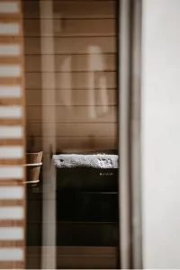 Die Aufnahme zeigt einen Raum mit einem Tisch und einem Fenster. Das Licht scheint durch die Jalousien.