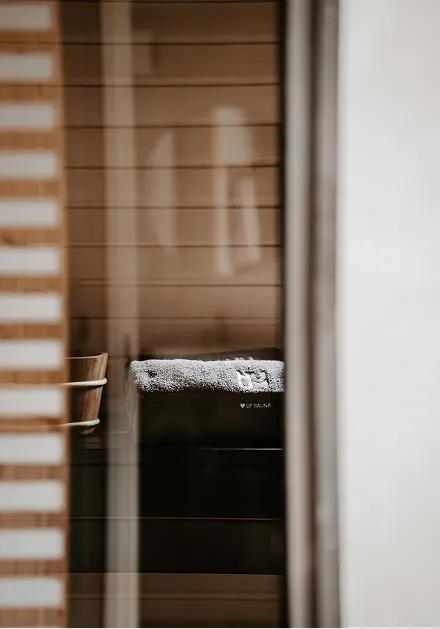 Die Aufnahme zeigt einen Raum mit einem Tisch und einem Fenster. Das Licht scheint durch die Jalousien.