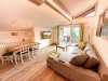 Wohnraum mit Tisch und Couch in einer Ferienwohnung Der Wohnraum zeigt einen Tisch, eine Couch und Fenster. Es ist hell und lädt zum Verweilen ein.