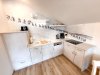 Küche mit Bergwandermotiv in einer Wohnung In der Wohnung sieht man eine moderne Küche mit einem Bergwandermotiv an der Wand und vielen Geräten und Utensilien.