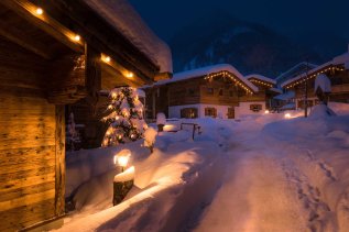 Verschneites Chalet Dorf in Burgberg bei Nacht.