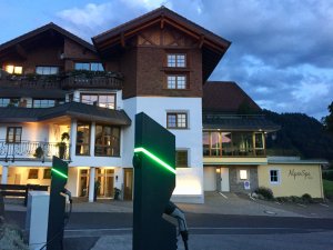 Die Außenansicht des Hotels Berwanger Hof in Obermaiselstein mit Ladesäulen für E-Autos.