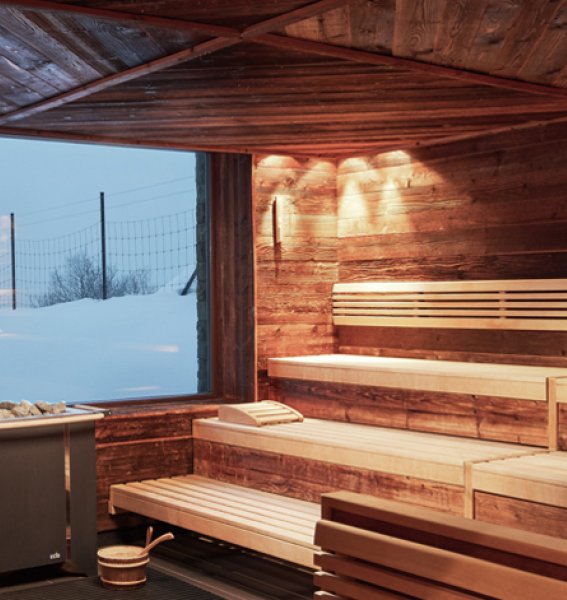 Sauna im Hotel Bergkristall - Mein Resort im Allgäu in Oberstaufen mit großem Fenster welches im Bild Rehe im Schnee zeigt