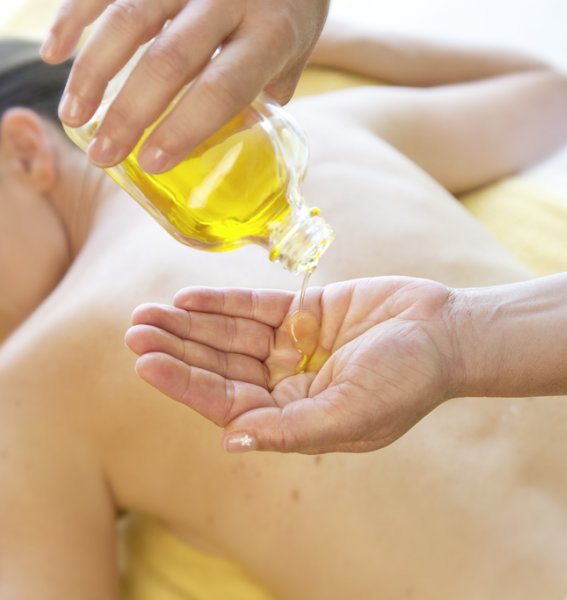 Eine Frau genießt eine wohltuende Massage im Biohotel Eggensberger in Füssen / Hopfen am See