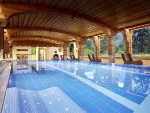 Innenpool des Hotel Prinz-Luitpold-Bads in Bad Hindelang mit großen Glasfenstern und Ruheliegen