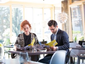 Ein Paar wählt seine Speisen auf der Speisekarte im Freiberg Romantik Hotel in Oberstdorf.