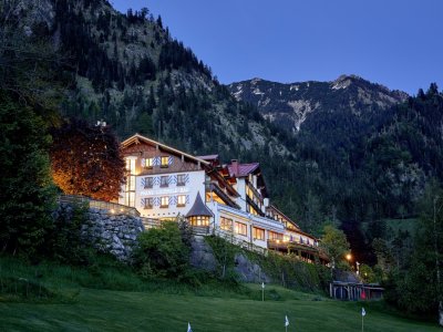 Außenansicht des Hotel Prinz-Luitpold-Bad in Bad Hindelang an einem schönen stimmungsvollen Sommer-Abend mit Blick auf die umliegenden Berge und Landschaft