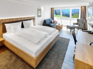 Zimmeransicht mit gemütlichen Doppelbett, Sofa und sonstiger Ausstattung des Kühbergs - Das Hotel über Oberstdorf in Oberstdorf