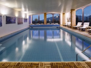 Blick auf den großen Indoorpool im Wellnessbereich des Wellnesshotel Mittelburg in Oy-Mittelberg.