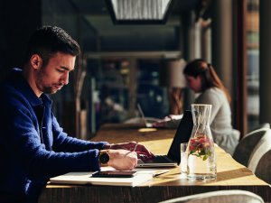 Ein Mann sitzt an einem Tisch im A-Rosa Ifen Hotel Kleinwalsertal in Hirschegg und arbeitet