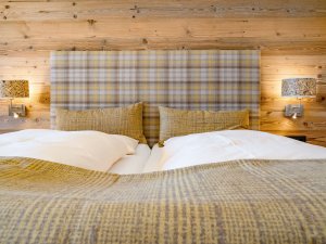 Einblick in eines der modernen Zimmer mit gemütlichem Bett im Biohotel Eggensberger in Füssen / Hopfen am See.