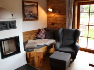 Einblick in eines der gemütlich eingerichteten Alpzitt Chalets in Burgberg mit Kamin und Sitzecke.