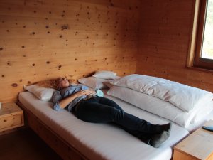 Eine Frau entspannt sich in einem der gemütlichen Doppelbetten im Biohotel Mattlihüs in Bad Hindelang