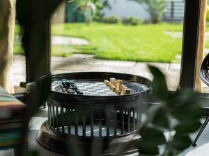 Ein Tisch zum Schachspielen in der Lounge mit großen Fenstern im Freiberg Romantik Hotel in Oberstdorf.