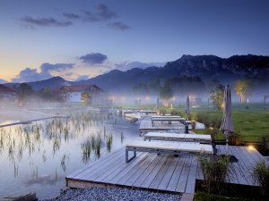 Der Außenpool im Hotel König Ludwig in Schwangau an einem Sommermorgen im Nebel.