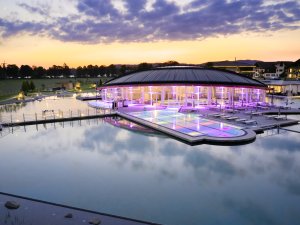 Der hell beleuchtete Außenpool an einem Sommerabend im Hotel König Ludwig in Schwangau.