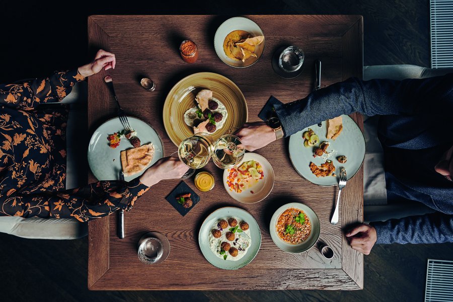 Travel Charme Ifen Hotel Speisen Ein Paar genießt die ansprechend angerichteten Speisen im Restaurant des Travel Charme Ifen Hotels im Kleinwalsertal.