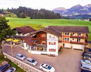 Außenansicht des Hotels Alpenblick in Fischen im Sommer mit Bergpanorama.