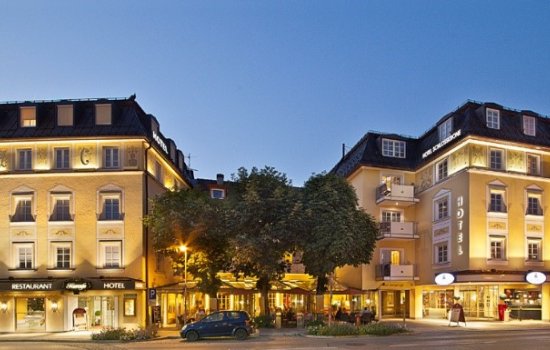 Außenansicht des Hotels Schlosskrone in Füssen mit Blick auf das stimmungsvoll beleuchtete Hotelgebäude
