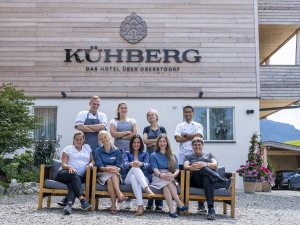 Mitarbeiter haben sich für ein Gruppenfoto vor dem Kühberg Das Hotel über Oberstdorf aufgestellt