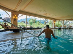 Ein Paar genießt den Wellnessbereich mit Innenpool im Schüle's Gesundheitsresort & SPA in Oberstdorf