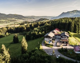 Außenansicht des Berghotels Sonnenklause in Sonthofen im Sommer mit Blick von einer Drohne im Himmel auf das Hotelgebäude und die umliegende schöne Landschaft