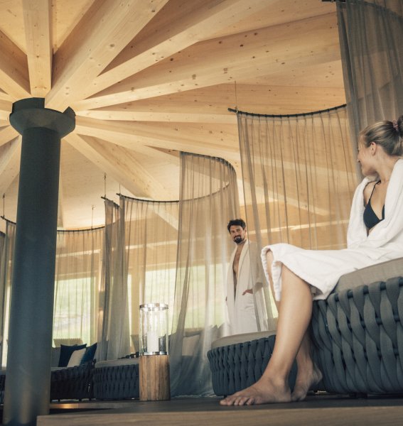 Einblick in den Wellnessbereich im Hotel Torghele's Wald & Fluh in Balderschwang mit Blick auf Ruheliegen und zwei Personen, die es sich bequem gemacht haben