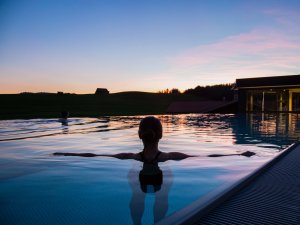 Eine Frau beim Baden im Außenpool des Haubers Naturresorts in Oberstaufen