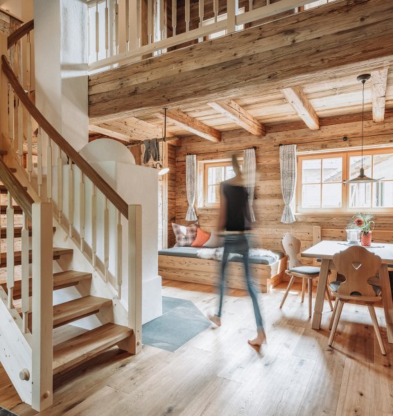 Einblick in eines der Chalets im Alpzitt Chalet im Dorf in Burgberg mit Blick auf eine gemütliche Sitzecke und die Treppe nach oben