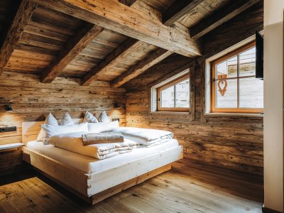 Einbick in eines der Schlafzimmer im Alpzitt Chalet im Dorf in Burgberg mit Blick auf ein gemütliches Doppelbett