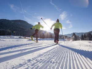 Zwei Personen beim Langlaufen auf den Loipen rund um das Sonnenalp Resort in Ofterschwang