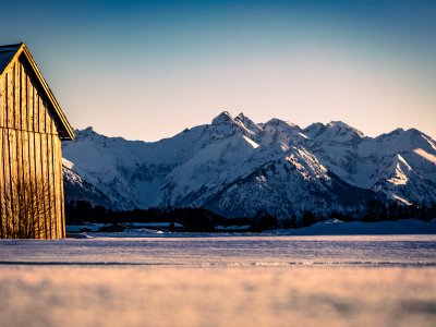 Es ist die Loipe in Burgberg im Winter zu sehen beim Sonnenuntergang und Bergpanorama.