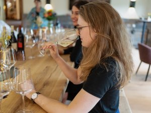 Eine Frau probiert am Tisch mit weiteren Personen verschiedene Weine im Hotel Sommer in Füssen
