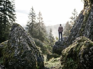 Eine Person genießt den Ausblick bei einer Wanderung in den Bergen in der direkten Umgebung des Hotels HUBERTUS Mountain Refugio Allgäu in Balderschwang