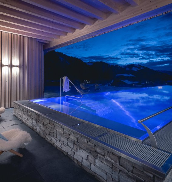Ansicht vom Außenpool mit abendlicher Stimmung im Winter vom Hotel Torghele's Wald & Fluh in Balderschwang im Winter