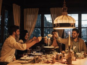 Freunde genießen zusammen eine Mahlzeit im Hotel Das Rübezahl in Schwangau