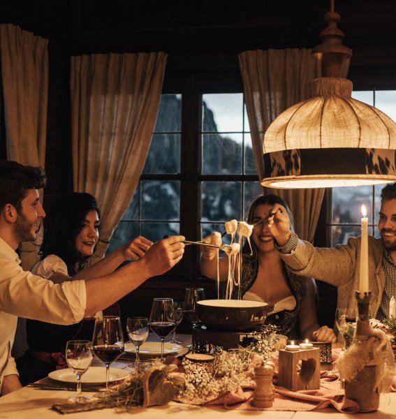 Freunde genießen zusammen eine Mahlzeit im Hotel Das Rübezahl in Schwangau