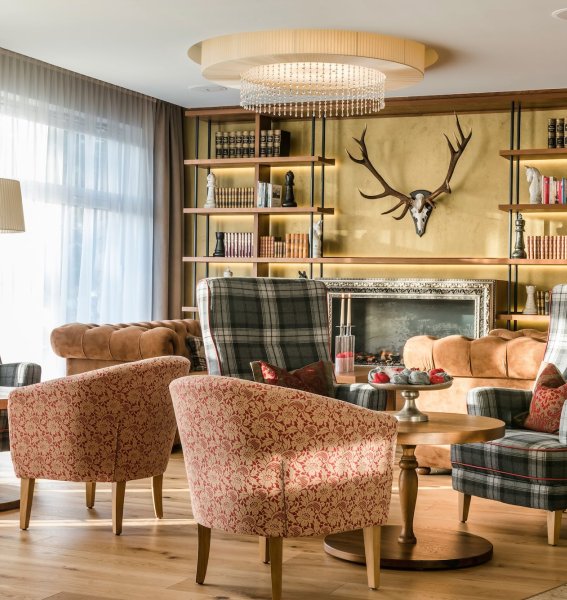 Einblick in die Lobby im Hotel Das Rübezahl in Schwangau mit gemütlichen Sesseln und Bücherregalen