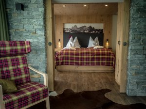 Einblick in eines der Zimmer im Allgäuhotel Tanneck in Fischen im Allgäu mit Blick auf das Doppelbett