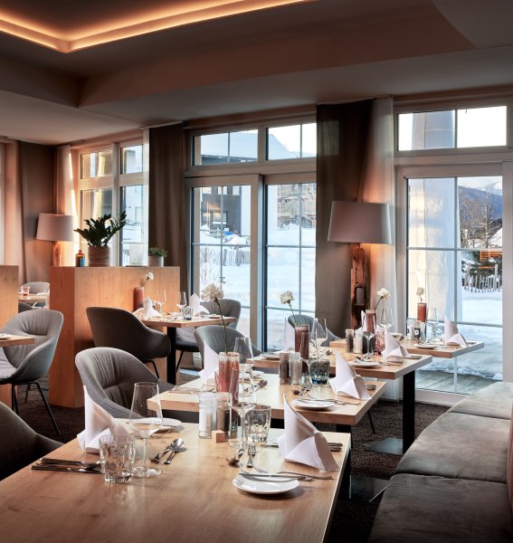 Der moderne Speiseraum im Panoramahotel Oberjoch mit warmen Braun- und Holztönen
