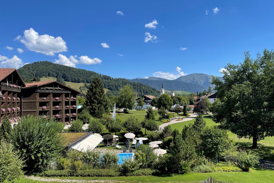 Außenansicht vom Parkhotel Lindner in Oberstaufen im Sommer mit Blick auf das Gebäude und grünen Wiesen