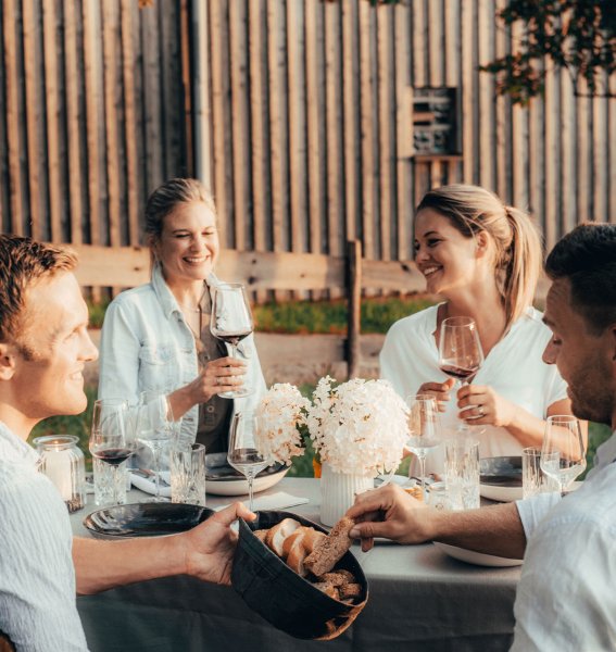 Freunde sitzen im Alpzitt Chalet im Dorf in Burgberg im Garten zusammen und speisen