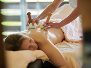 Ein Gast im SCHÜLE's Gesundheitsresort & SPA in Oberstdorf erhält eine entspannende Massage mit Stempeln