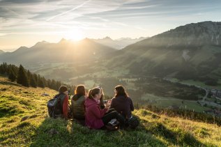 Eine Gruppe von Gästen im Alpin Chalet in Oberjoch machen beim Wandern in den Bergen eine Pause