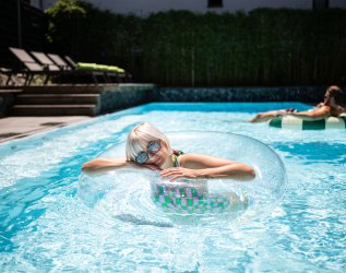Gäste genießen den Sommer im Außenpool vom Freiberg Romantik Hotel in Oberstdorf