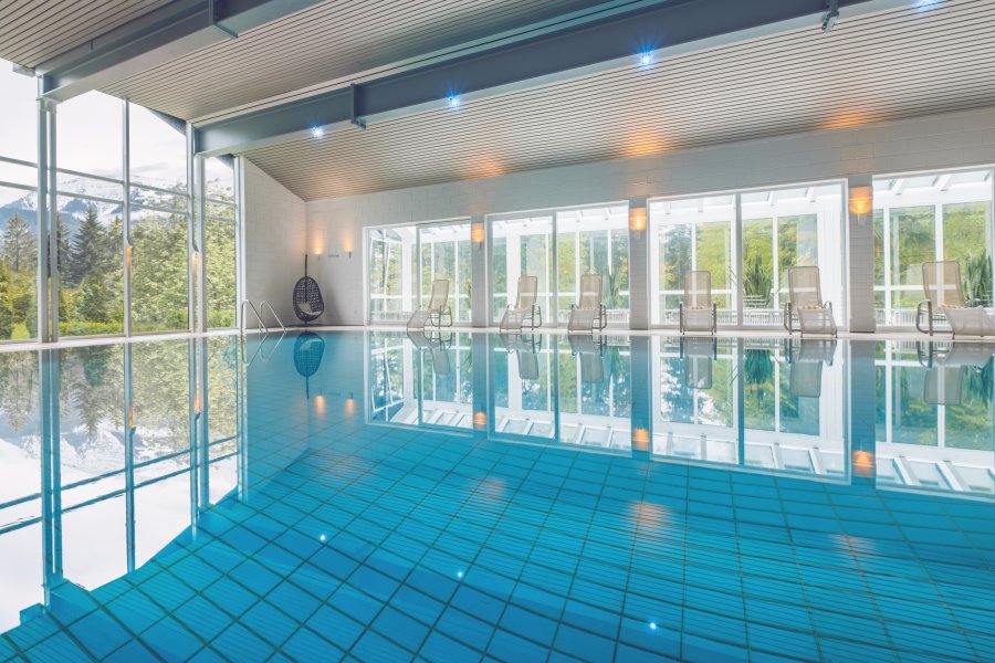 Einblick in den großen Innenpool mit Fensterfront im Mondi Resort in Oberstaufen